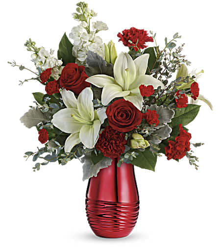 Teleflora's Radiantly Rouge Bouquet - Sweep them off their feet with this luxurious bouquet of red roses and fragrant white lilies, presented to perfection in a radiant rouge ceramic vase! Red roses, white asiatic lilies, red carnations, red miniature carnations, and white stock are arranged with dusty miller, parvifolia eucalyptus, and lemon leaf. Delivered in a Radiantly Rouge Vase. Approximately 17 1/2&quot; W x 20 1/2&quot; H 