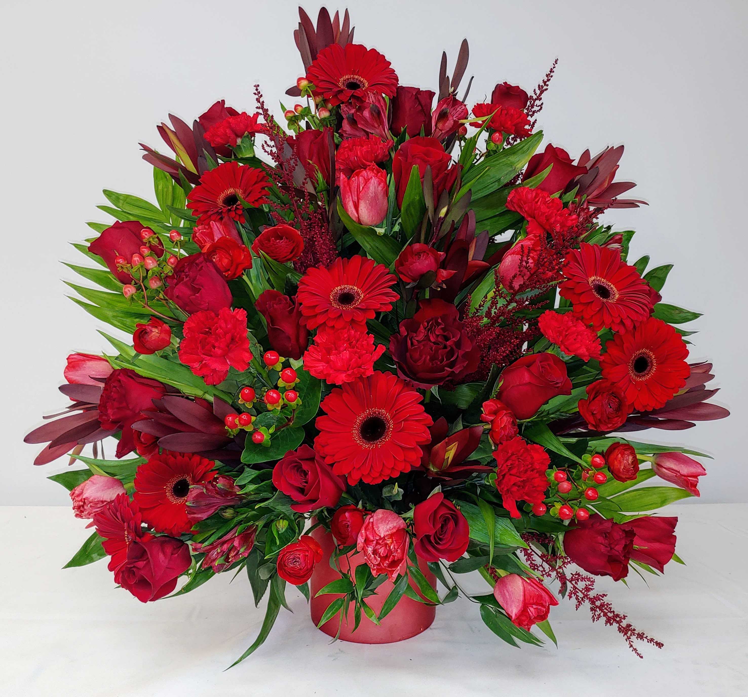Red Assortment in Red Container - Assortment of Red Blooms and greenery