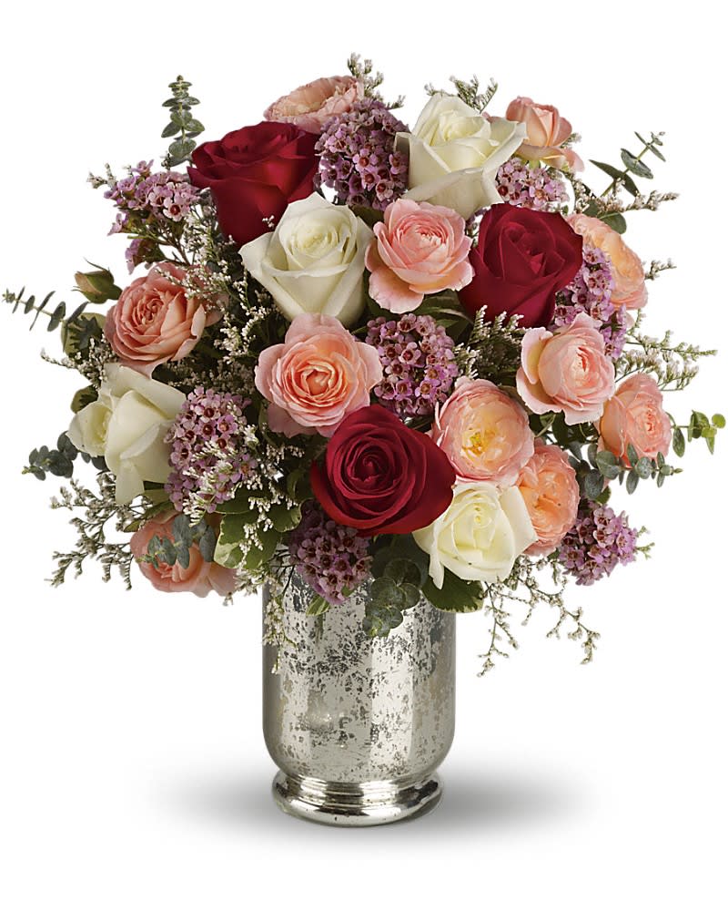 Teleflora's Always Yours Bouquet - Let her know that you are always hers by sending this enchanting rose bouquet. It offers red roses for romance white roses for loyalty and coral to convey desire. What&#039;s more this stunning arrangement is elegantly hand-delivered in a silver mercury glass hurricane vase. Pastel roses and spray roses pink waxflower white limonium and stylish eucalyptus are delivered in a divine vase. This beauty definitely says love always.
