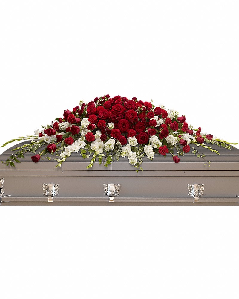Garden of Grandeur Casket Spray - A traditional tribute that communicates deep love and eternal commitment. This dramatic red and white casket spray is ideal for a full couch or closed casket mixing dozens of deep red roses with the pure white beauty of gladioli and stock. Red roses spray roses and carnations along with graceful white gladioli and stock are arranged beautifully with ivy and salal.