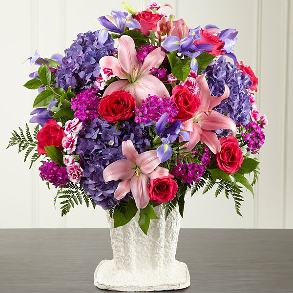 The FTD We Fondly Remember Arrangement The FTD We Fondly Remember Arrangement - This generously scaled arrangement makes a beautiful and comforting expression of sympathy. This impressive colorful combination of pink roses and Asiatic lilies vibrant blue iris fuchsia dianthus purple carnations and hydrangea is handcrafted by an FTD artisan florist. An extraordinary choice that thoughtfully expresses your love and profound sense of loss for a wake funeral or graveside burial service.