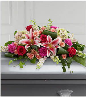 The FTD® Splendid Grace™ Casket Spray - An extraordinary way to pay your respects to someone very close, this colorful mixed flower casket spray beautifully delivers your sincere expression of love and sympathy. Traditionally ordered by the deceased's immediate family, this casket enhancement handcrafted by a local FTD artisan florist, includes larkspur, roses, carnations, hydrangeas and Stargazer lilies complemented with lush greens including aspidistra, salal and ivy vines. It is made to fit over the closed portion of a casket cover during visitation at a funeral home, at a funeral service and at a graveside ceremony at the cemetery. Your purchase includes a complimentary personalized gift message.