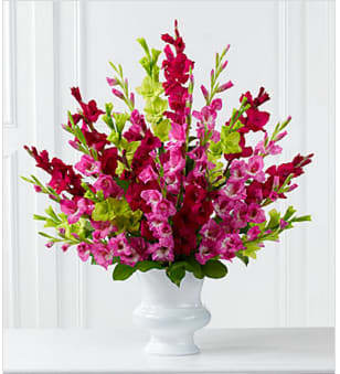 The FTD® Solemn Offering™ Arrangement - The FTD® Solemn Offering™ Arrangement is a bright and beautiful way to say your final farewell. Fuchsia, magenta and jade gladiolus are accented with lush greens and displayed in a white plastic urn to commemorate the life of the deceased wtih fantastic color and elegance. GOOD arrangement includes 25 stems. Approximately 34&quot;H x 34&quot;W. BETTER arrangement includes 31 stems. Approximately 35&quot;H x 35&quot;W. BEST arrangement includes 37 stems. Approximately 36&quot;H x 36&quot;W. Your purchase includes a complimentary personalized gift message.