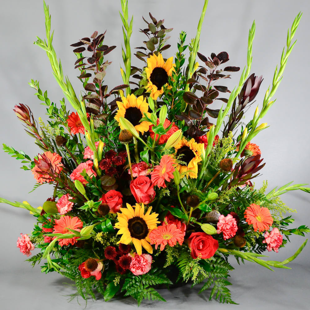 WARM THOUGHTS ONE SIDED ALTAR - Our WARM THOUGHTS ONE SIDE ALTAR comes with yellow glads, sunflowers, gerbers, carnations, roses pom pom, safari sunset &amp; other seasonal flowers and greenery!! 