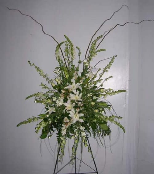 A Walk In the Woods, Large white and Green Easel Spray A Walk In the Woods, Large white and Green Easel Spray - The focal flowers are fragrant white lilies surrounded with smaller white linear flowers.Strong branches of curly willow direct your eyes upward like admiring a stately tree.