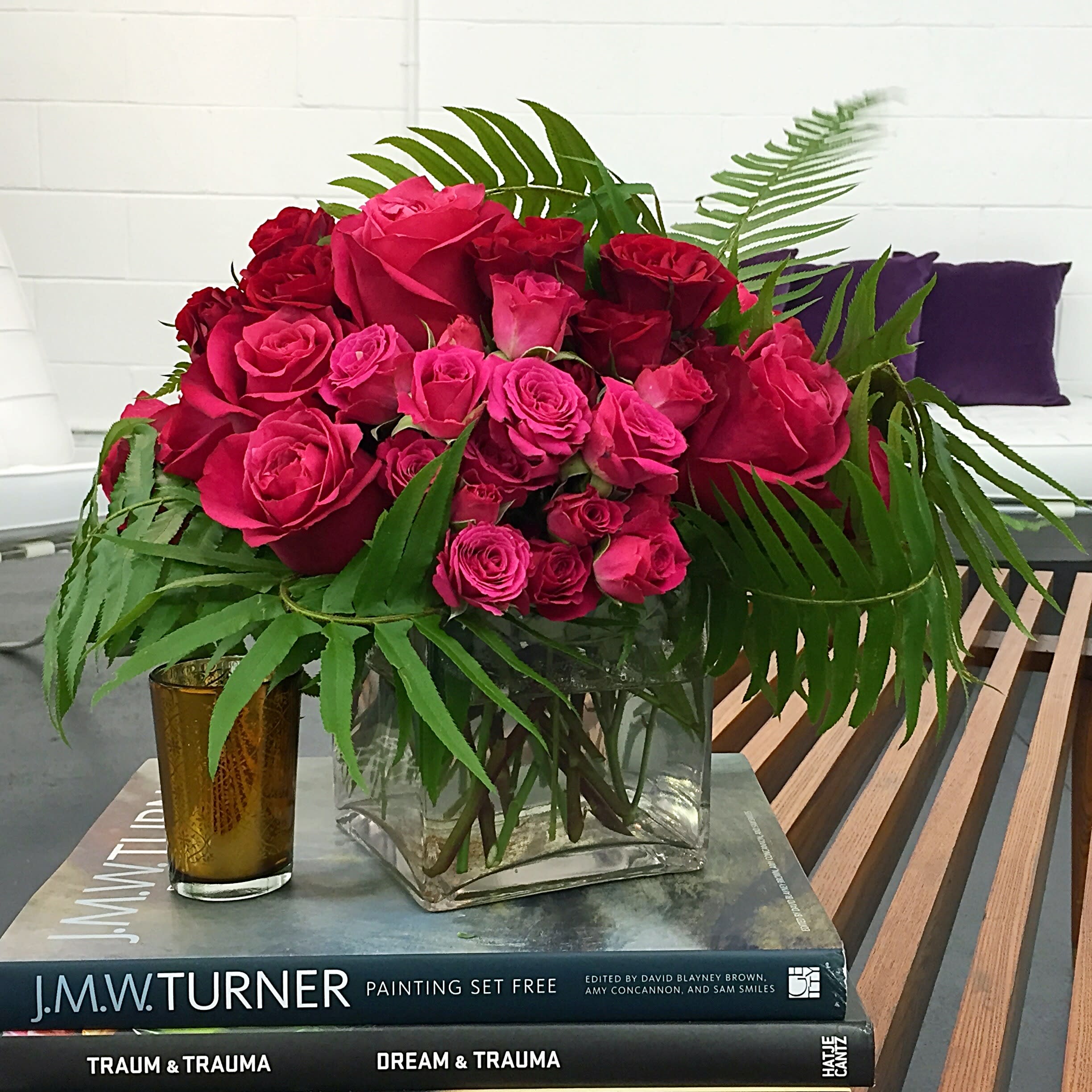 Red Velvet Roses - This Enchanting Arrangement is filled with three shades of Luxurious Roses- Fuchsia, Red and Hot Pink, wrapped in Green Fern, in a 5&quot; square clear glass vase. 