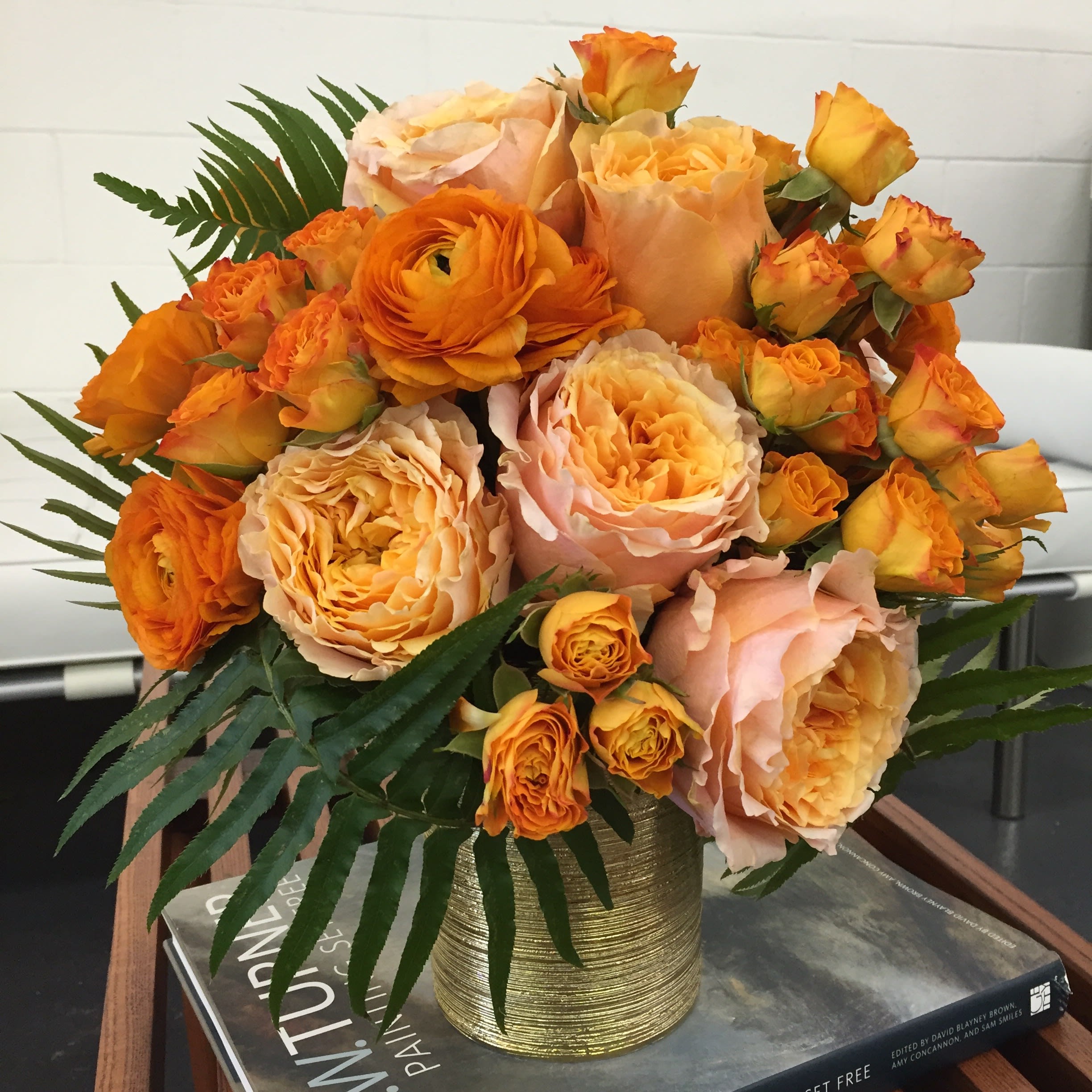 Orange Sorbet Roses and Ranunculus - Stunning and Artistic, this arrangement is a beautifully wrapped gathering of Ranunculus, Garden Roses and Garden Spray Roses in shades of Peach and Orange Sorbet.
