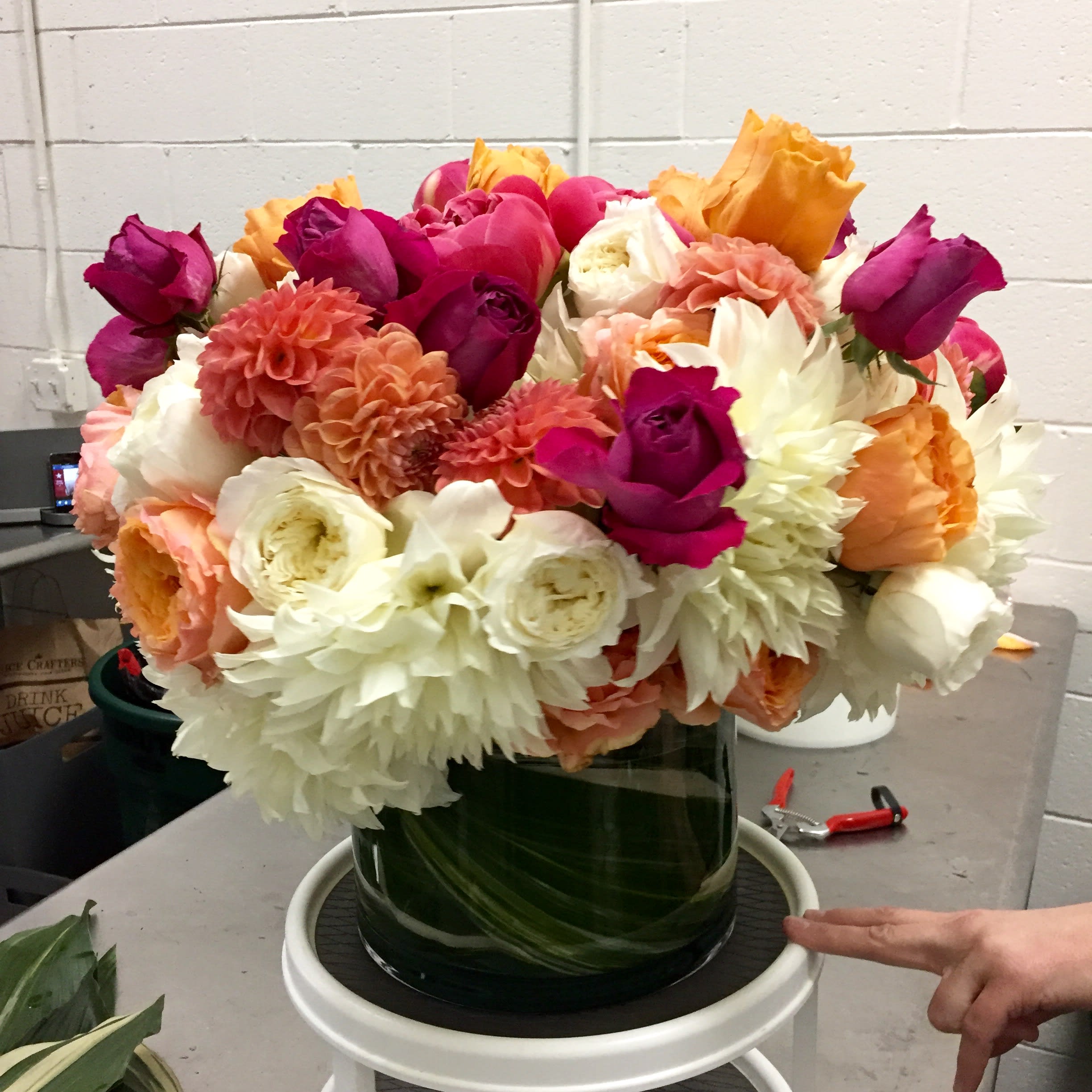 Delicious Sherbet - Raspberry, Orange Sherbet and White Dahlias and Garden Roses spill out of an Elegant leaf wrapped vase.  This is a Sumptuous gift that will fill her heart with Love!