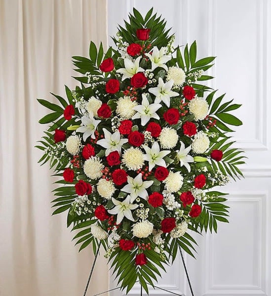 Red and White Sympathy Standing Spray - A warm embrace. A kind word. A memorable gesture. There are many ways to express how we feel after the loss of a loved one. Our beautiful standing spray arrangement, meticulously handcrafted by expert local florists with radiant red roses and peaceful white blooms, provides a thoughtful statement of your care and support when it’s needed most.  Standing spray arrangement with red roses and hypericum; white Asiatic lilies, football mums, stock, red carnations and monte casino; accented with soft, lush greenery  measures approximately 56&quot;H x 38&quot;L without stand  Arrives on an easel Appropriate for the funeral home or gravesite We use only the freshest flowers available, so colors and varieties may vary due to availability