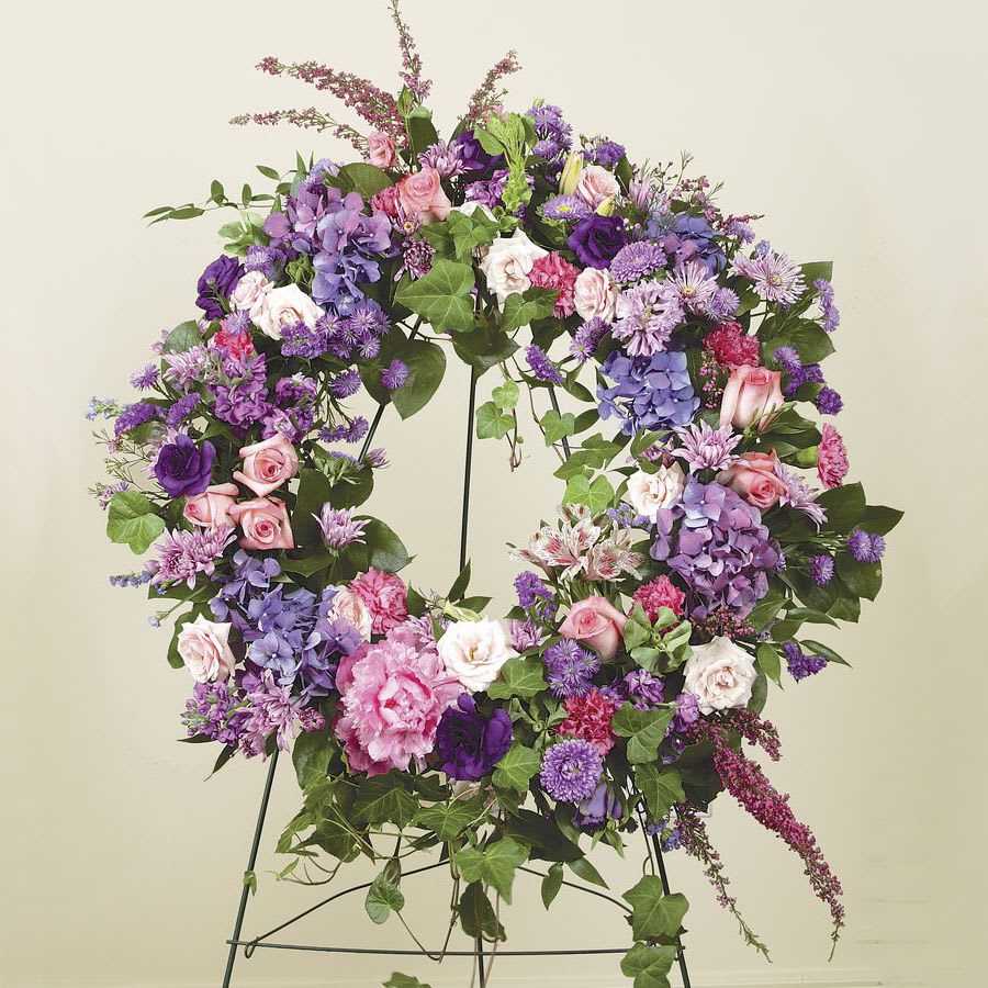 HEATHER AND LISI IN WREATH OF REMEMBRANCE - Heather, Lisianthus and others beautifully arranged with mixed greenery and arrayed as a wreath 