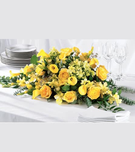 Golden Garden Centerpiece  - This centerpiece holds sunny, golden garden flowers. Yellow roses, yellow mini calla lilies, yellow dendrobium orchids and green hydrangea with baby blue and seeded eucalyptus will cast a happy glow for your reception or party.
