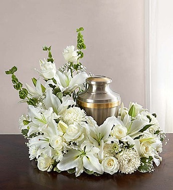 Cremation Wreath - All White - Honor a life so beautifully lived. Our florists artistically hand-design an asymmetrical all-white table wreath arrangement with roses, lilies, carnations and more. An urn or framed photograph can be placed in the open center, creating a comforting tribute for the cremation or memorial service.