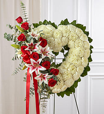 Red Rose and Lily Open Heart Standing Spray - The passing of someone we love deeply requires a special tribute. Our open heart standing arrangement of fresh white blooms, accented by red roses and Stargazer lilies cascading down one side and adorned with a red satin ribbon, will help you express the devotion and sympathy in your heart.