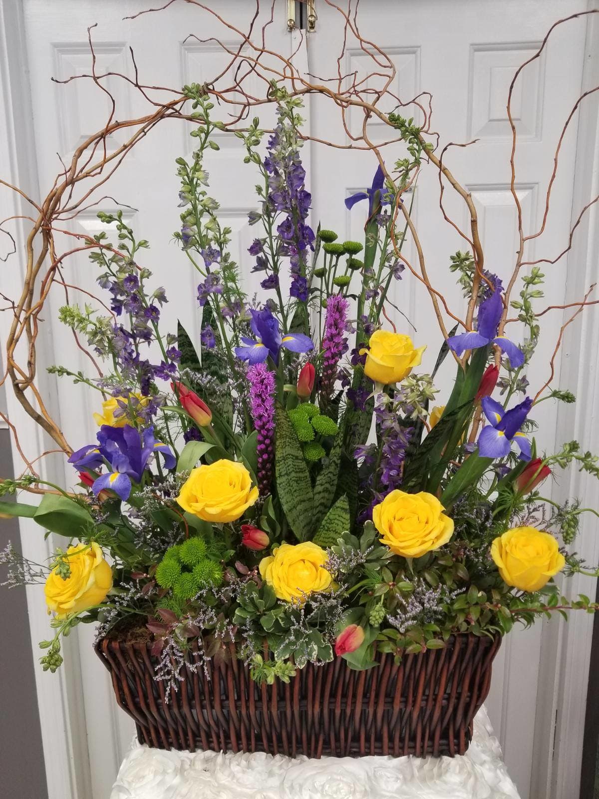 Willow Garden Arrangement Willow Garden Arrangement - The Willow Garden Arrangement includes Liatris, Delphinium, Roses, Buttons, Tulips, Iris and Caspia.2