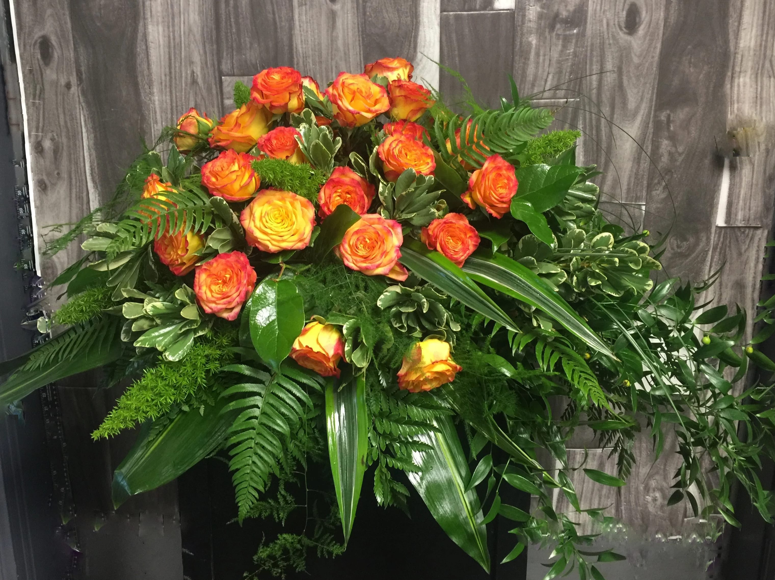 Graceful Garden Casket Spray Graceful Garden Casket Spray - This graceful casket spray of bright bi-colored roses against a backdrop of lush greenery, will celebrate a life well-lived.