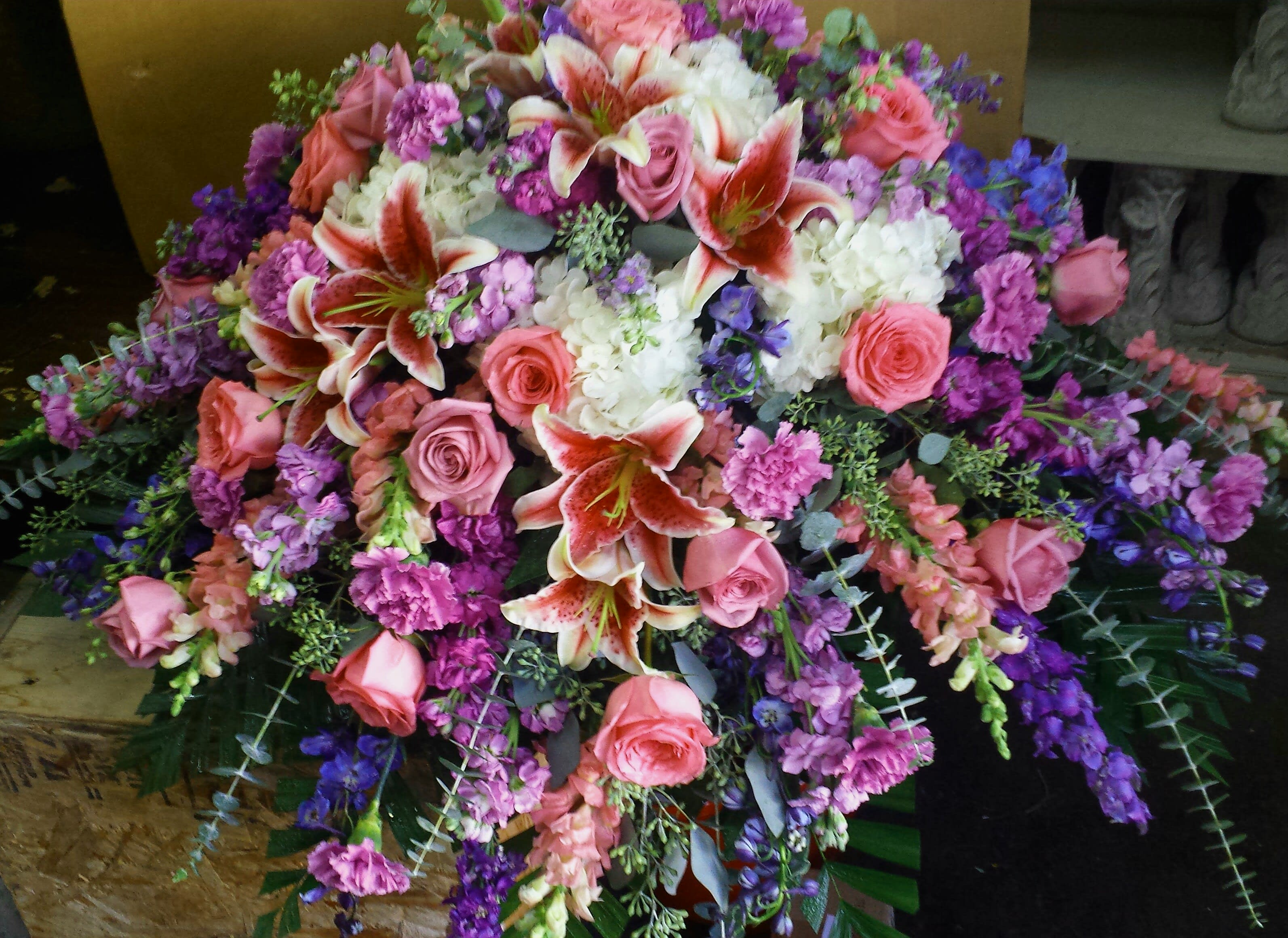 Eckert Florist's Stargazer Casket Spray Eckert Florist's Stargazer Casket Spray - This casket spray features stargazer lilies, hydrangeas and a mix of our finest blooms in pinks, lavenders and purples.