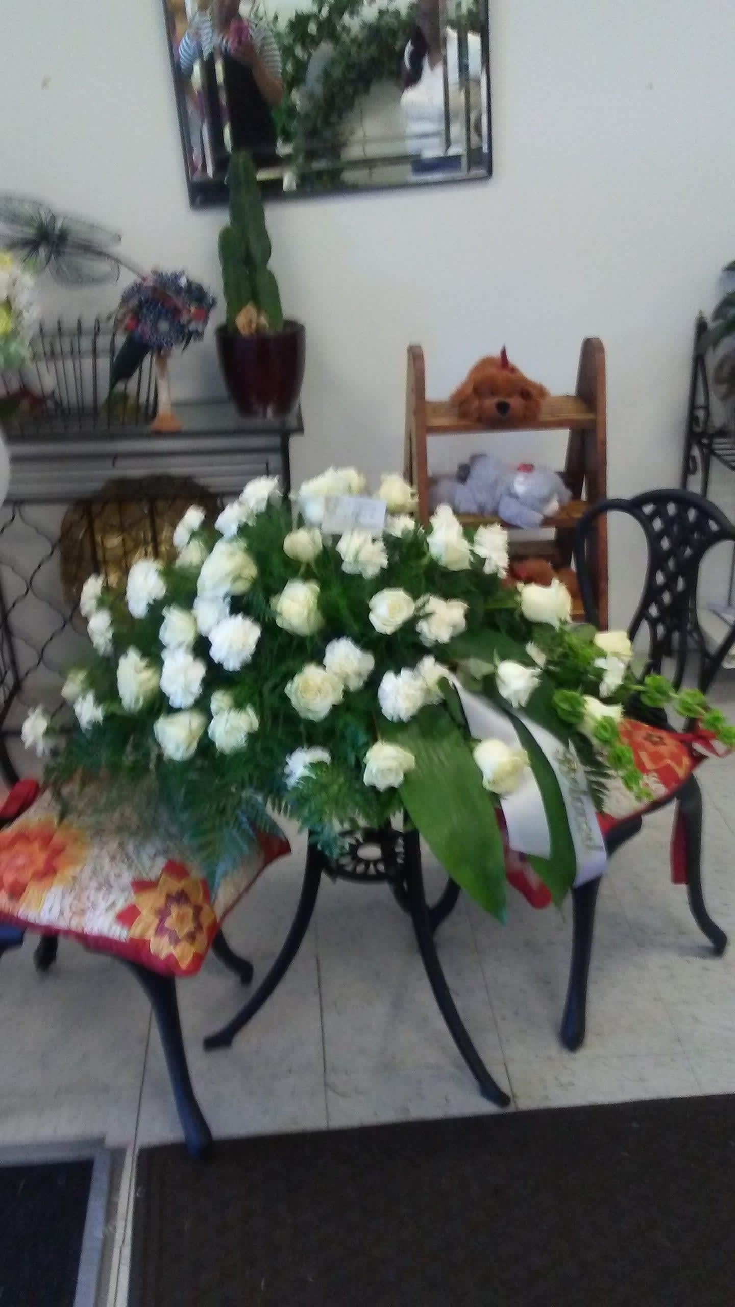 White casket spray - White roses carnations Bells of Ireland and assorted greens.