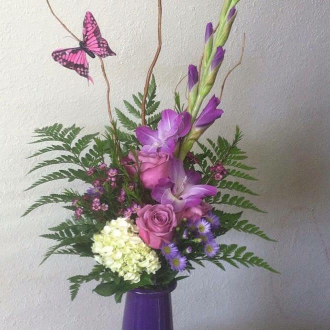 Purple Gladiola Bouquet - Purple gladiola bouquet in a vase, accented with hydrangea, purple roses, curly willow, and beautiful butterfly. 