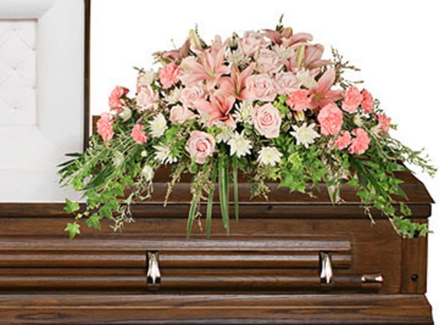 Softly at Rest - Softly at Rest features a lush assortment of Ivy, Salal, Variegated Pittosporum, Leather Leaf, Variegated Liriope, Pale Pink Roses, Pale Pink Lilies, Pink Carnations, White Cushion Poms, and White Calycina artfully arranged in an elegant casket spray.   Copyrighted content provided by FlowerShopNetwork.com Proud Member of Flower Shop Network