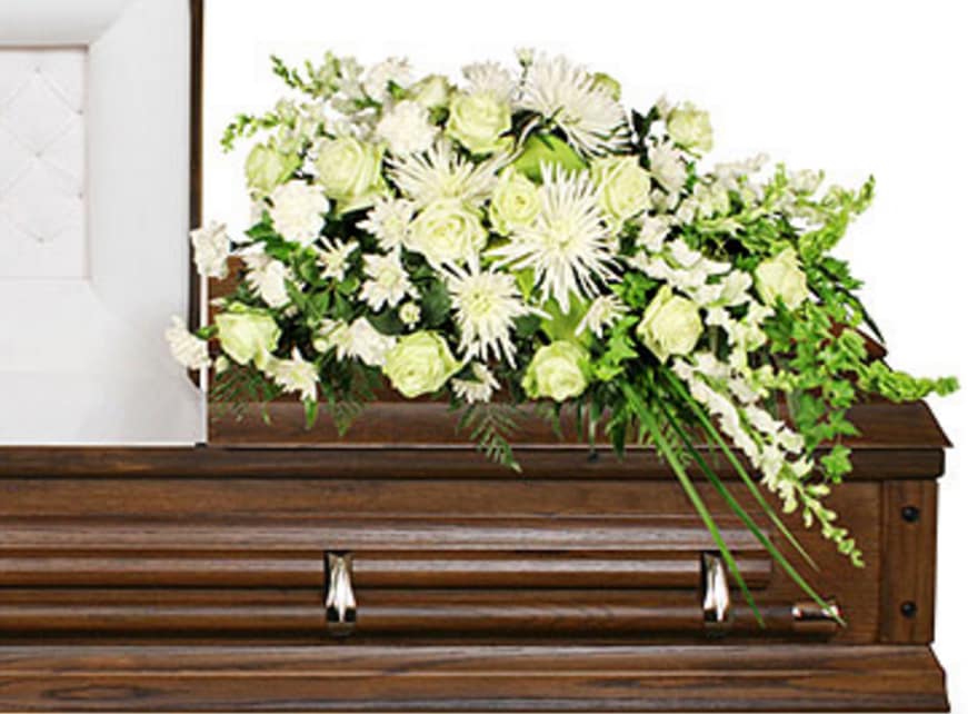CF2115 - Quiet Commemoration Quiet Commemoration features Palm, Leather Leaf, Variegated Pittosporum, Ivy, Hosta Leaves, Liriope, White Carnations, White Cushion Poms, White Roses, White Spider Mums (Fuji), White Snapdragons, and Bells Of Ireland.   Copyrighted content provided by FlowerShopNetwork.com Proud Member of Flower Shop Network