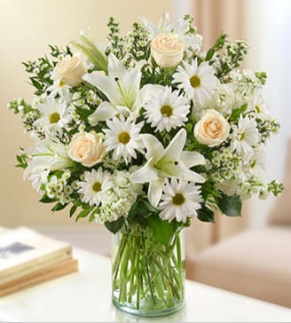 BN95380 - Sincerest Sorrow - All White Express your sincere condolences with our elegant all-white arrangement of roses, lilies, stock, daisy poms and monte casino. A peaceful tribute that offers treasured memories of loved ones. 