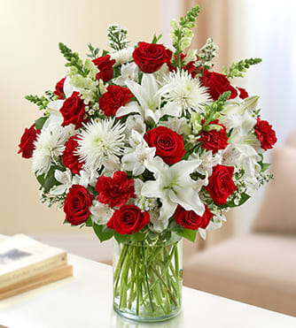 BN95404 - Sincerest Sorrow - Red and White Express a memorable tribute during times of sorrow with our lush red and white vase arrangement. Roses, lilies, snapdragons, spider mums, carnations and alstroemeria send a message of your deepest sympathy to friends and family members, beautifully arranged by our expert florists. 
