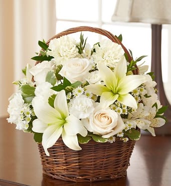 95383 - Peace, Prayers, &amp; Blessings- All White Make a heartfelt gesture of your sympathy with our classic all-white basket arrangement of roses, lilies, alstroemeria, carnations and monte casino. Hand-gathered into a lovely willow handled basket, it’s a simple yet touching way to offer peace and comfort during their time of sorrow. 