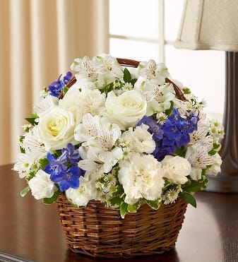  95413 - Peace, Prayers &amp; Blessings - Blue and White Offer peace and comforting prayers during times of loss with this elegant blue and white basket arrangement. A pair of graceful doves sits atop a gathering of fresh roses, delphinium, alstroemeria and carnations, beautifully hand-designed by our florists. Please note: doves are available in select areas only. Check with your local florist.