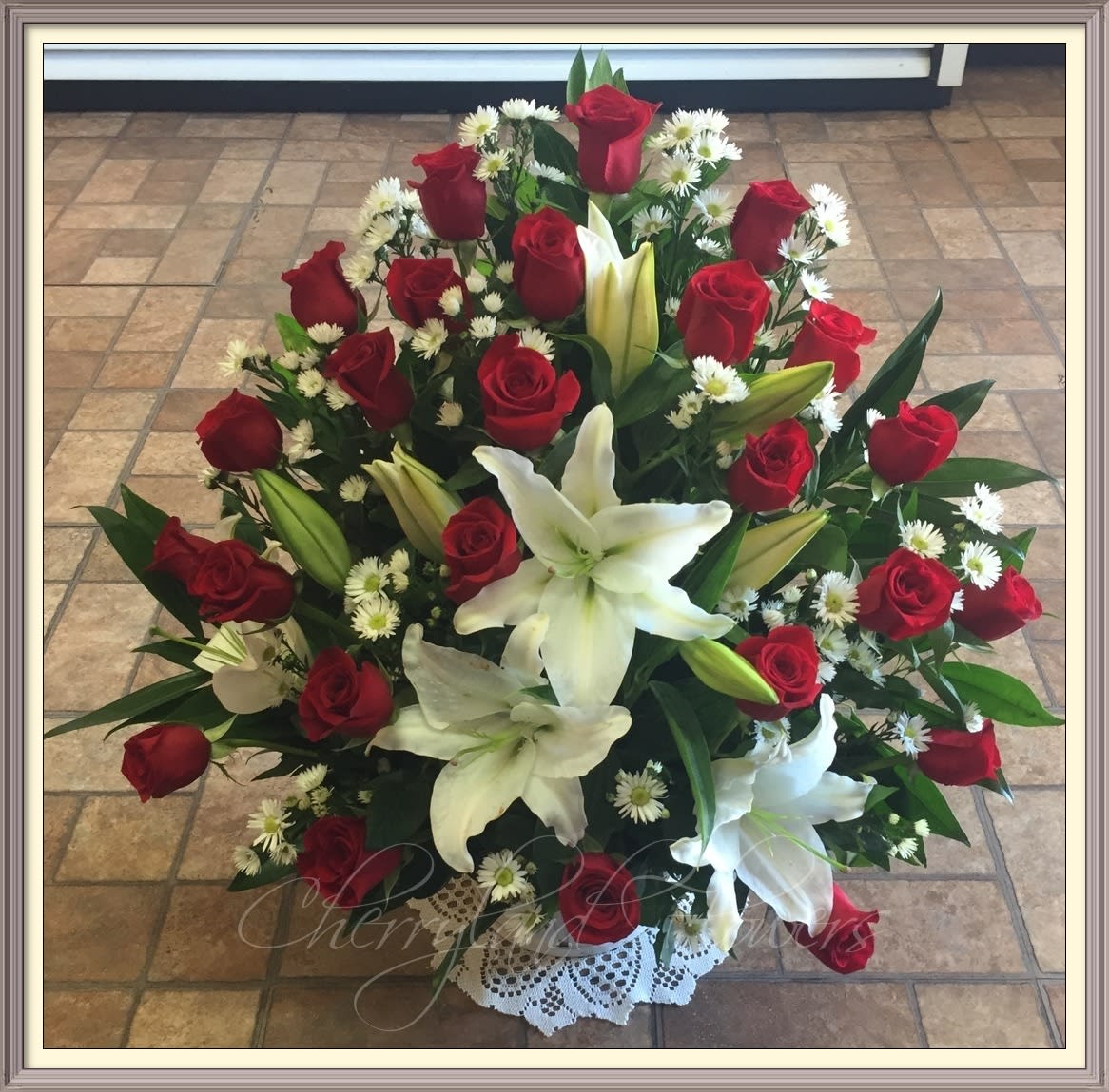 Amore' Amore' - Long stem red roses, white lilies, monte casino, and foliage artfully arranged in an elegant white container.