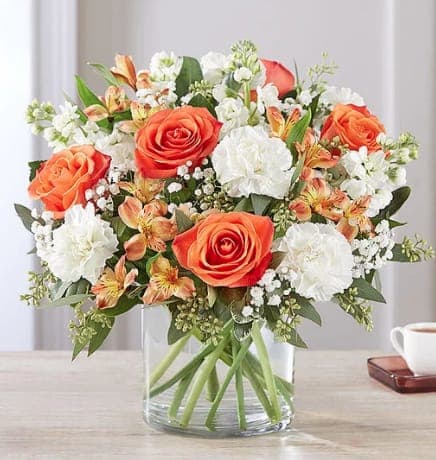 Sweet Citrus - The sweet citrus shades in our charming new bouquet bring your sentiments to life. Loosely gathered inside a clear cylinder vase, the mix of vibrant orange and creamy white blooms makes special milestones and everyday moments even more memorable.