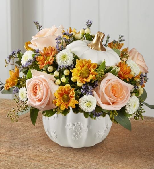 Autumn Essence Pumpkin Medley - We’ve captured the essence of autumn in a new and modern way. Our loosely gathered arrangement features a medley of peach and creamy-white blooms, with hints of gold and purple. It’s the perfect complement to our contemporary pumpkin container. With a white satin finish, embossed detail and rich golden accents, it’s an ideal pick for fresh flowers, wrapped candies or as a unique seasonal accent.