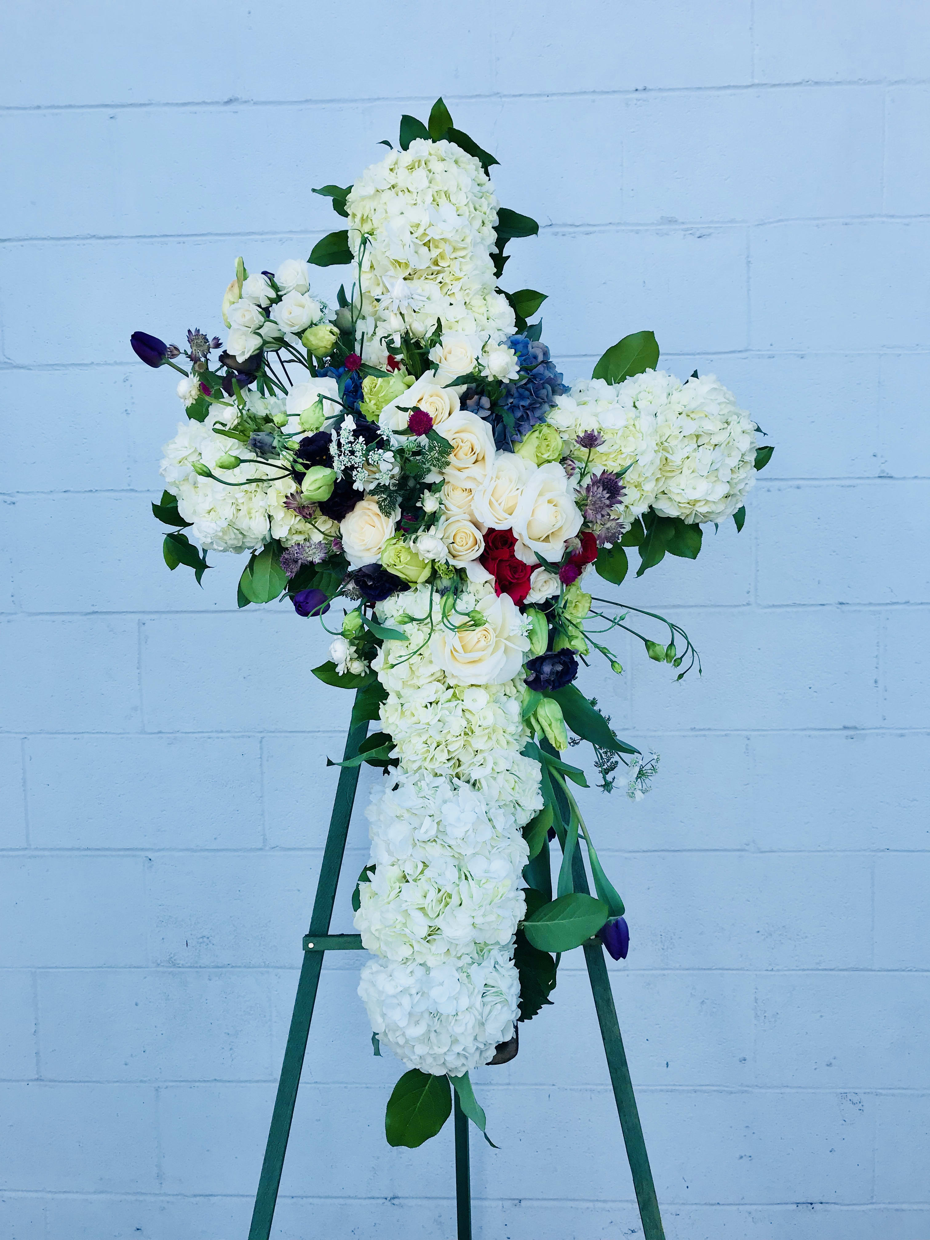 Belief - Designed on an easel- a full lush cross of beautiful flowers. If you want to have us do it a certain color just let us know. 