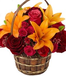 Fall Festival Basket - With glowing autumn-colored roses and lilies delightfully arranged in a basket with seasonal accents, this unique bouquet of fall flowers truly speaks volumes.Flowers are designed to be delivered as close to the arrangement pictured as possible