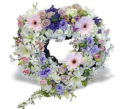 Soft Heart AF17 - A beautiful heart wreath arranged with soft tones of peaches, pinks, creams will truly express your deepest sympathy.