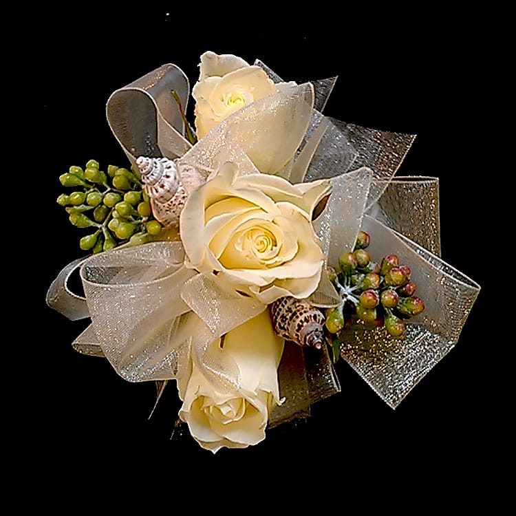 Seaside Rose Corsage ACW3 - Whether your event is near the ocean or not, this beautiful rose corsage with seashells, seeded Eucalyptus or other greens will be a hit! Choose as a pin on or wrist corsage and add your choice of wrist bands. Specify preferred color or roses and ribbon in comments section of order form. NOTE: WRIST CORSAGE BEADED AND CRYSTAL BANDS SOLD SEPARATELY. PLEASE CHOOSE PREFERRED BAND AND ADD TO ORDER. All Boutonnieres and Corsages should be ordered a minimum of 3 - 5 days prior to your event. For needs sooner than that please call the store at 858-454-0146 to ensure availability.
