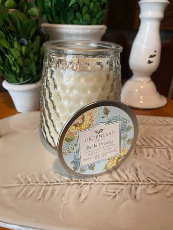 Bella Freesia Signature Candle - Freesia bouquets and delicate white tea flutter into citrus accords of tangerine and bergamot, while puffs of cotton blossom float on aromatic pools of amber to create one of our most-loved floral scents for every day, Bella Freesia. With a 13 oz hobnail glass jar and lid, this scented candle is perfect for gifting or every day decor! Each Greenleaf signature candle is made in the USA with soy-blend wax and a lead-free cotton wick. This candle will burn for up to 100 hours.