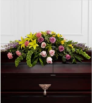 The FTD® Forever Beloved™ Casket Spray -  The FTD® Forever Beloved™ Casket Spray beautifully illuminates the atmosphere of thier final farewell service. Lavender roses, pink roses, lavender larkspur, pink carnations, Bells of Ireland, yellow Asiatic lilies, yellow freesia, solidago and lush greens are arranged to create an extravagant display of floral beauty that offers comfort and peace to the friends and family of the deceased. Approximately 43&quot;W x 30&quot;D. Your purchase includes a complimentary personalized gift message.