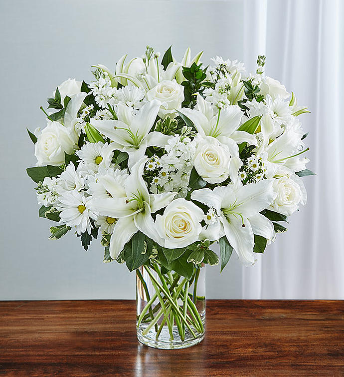 Sincerest Sorrow™ All White - Express your sincere condolences with our elegant all-white arrangement of roses, lilies, stock, daisy poms and monte casino. A peaceful tribute that offers treasured memories of loved ones. Abundant bouquet of the freshest white roses, lilies, stock, daisy poms and monte casino, accented with variegated pittosporum, salal and myrtle.