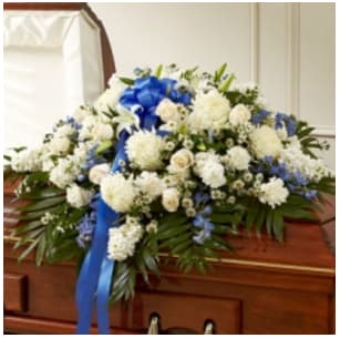 Blue &amp; White Cherished Rose Half Casket Cover - When someone this close and special passes, it’s important to celebrate all the love, care and devotion you feel for them. This half casket cover, crafted with painstaking care and artistry by our designers features long stem white roses, blue delphinium and more to create an unforgettable final tribute to a life well lived •Arrangement measures approximately 18&quot;H x 38&quot;L x 28&quot;D Product ID: 91222  