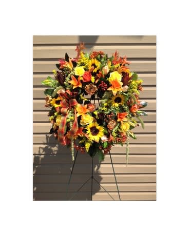 Autumn Cycle Wreath Autumn Cycle Wreath - This jaw-dropping standing wreath captures the best of the Autumn season. Sunflowers, lilies, roses, mums, solidago, hypericum berries, magnolia leaves and more make this the perfect arrangement. Flowers and colors may be substituted depending on availability and season. FCF-SW01