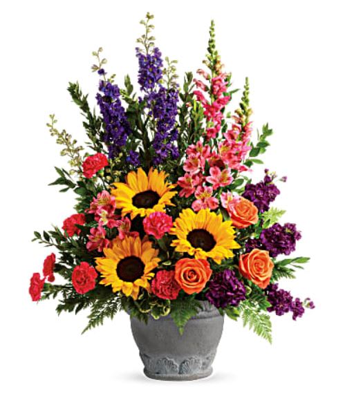 Hues of Hope Hues of Hope - Send a message of warmth and hope with this magnificent display of sunflowers and roses in a large antiqued pot, a colorful tribute that will warm their hearts. •This bright arrangement includes orange roses, pink alstroemeria, hot pink carnations, yellow sunflowers, purple larkspur, purple stock, hot pink snapdragons, myrtle, variegated pittosporum, and leatherleaf fern. •Delivered in Teleflora's Parisian Garden Pot. While supplies last. •Orientation: One-Sided