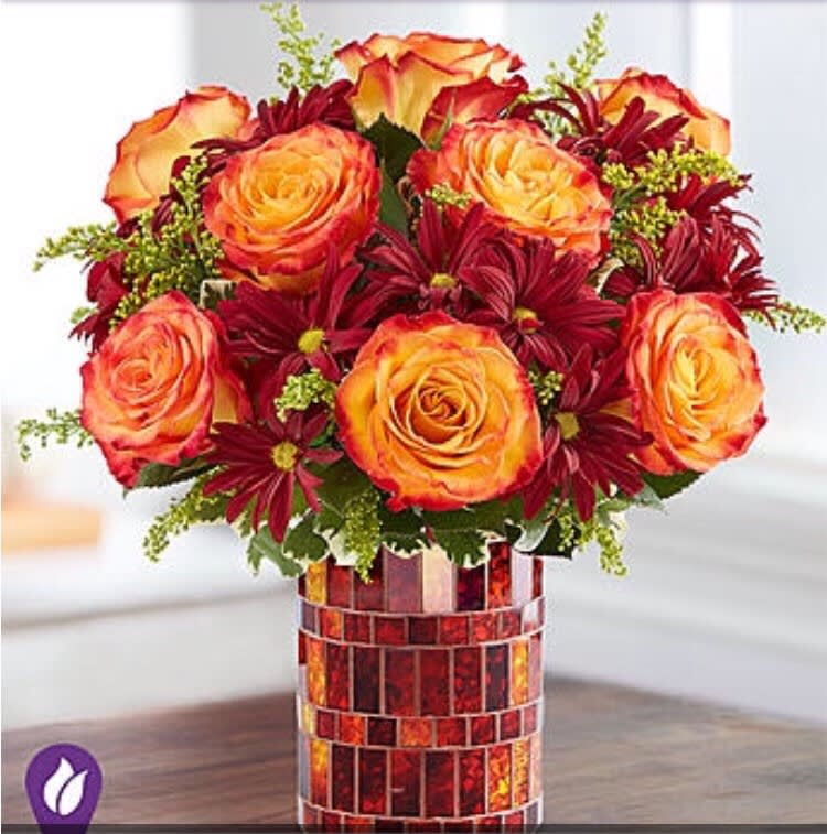 Amber Waves Bouquet - Our Amber Waves Bouquet arranged in a shimmering mosaic vase sets our unique autumn feel to brighten up yourself, family or friends home!! Floral arrangement includes bi-color orange roses; red daisy poms; and accented with assorted greenery!! 