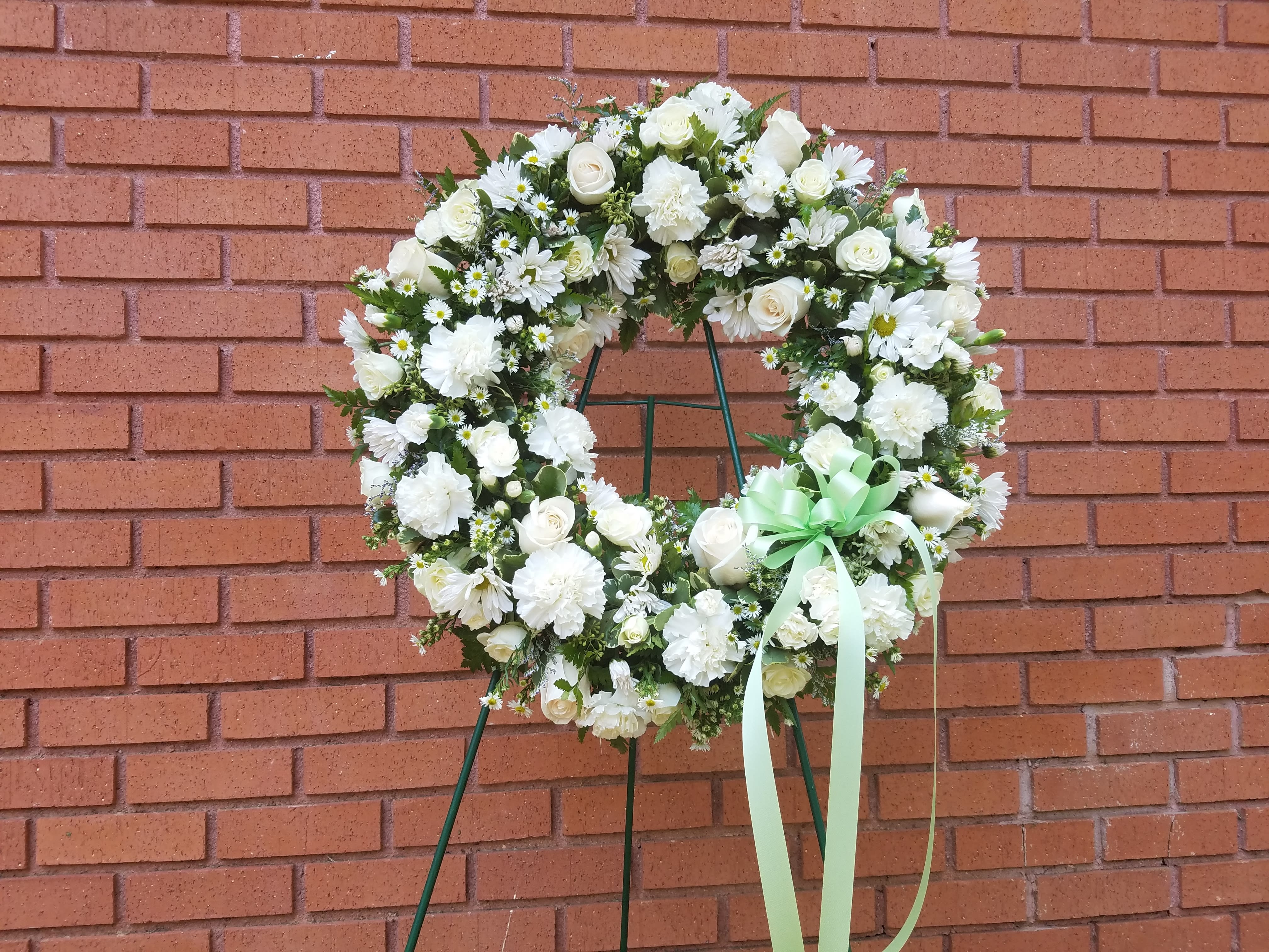 Scents of Heaven Scents of Heaven - Flower wreath arrangement complete with all white flowers, including roses, daisies, carnations, mini carnations, and monte casino. Includes stand.