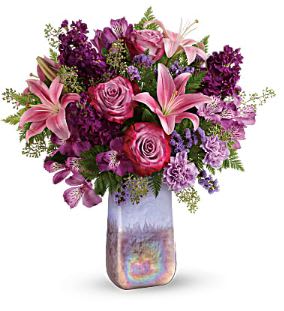 Amethyst Jewel Bouquet  - This bouquet features lavender roses, pink asiatic lilies, purple alstroemeria, lavender carnations, lavender sinuata statice, seeded eucalyptus, and leatherleaf fern.  Like a rare jewel, this regal arrangement is naturally breathtaking.  It's presented in a hand-blown amethyst colored art glass vase that shimmers with a beautiful iridescent finish. 
