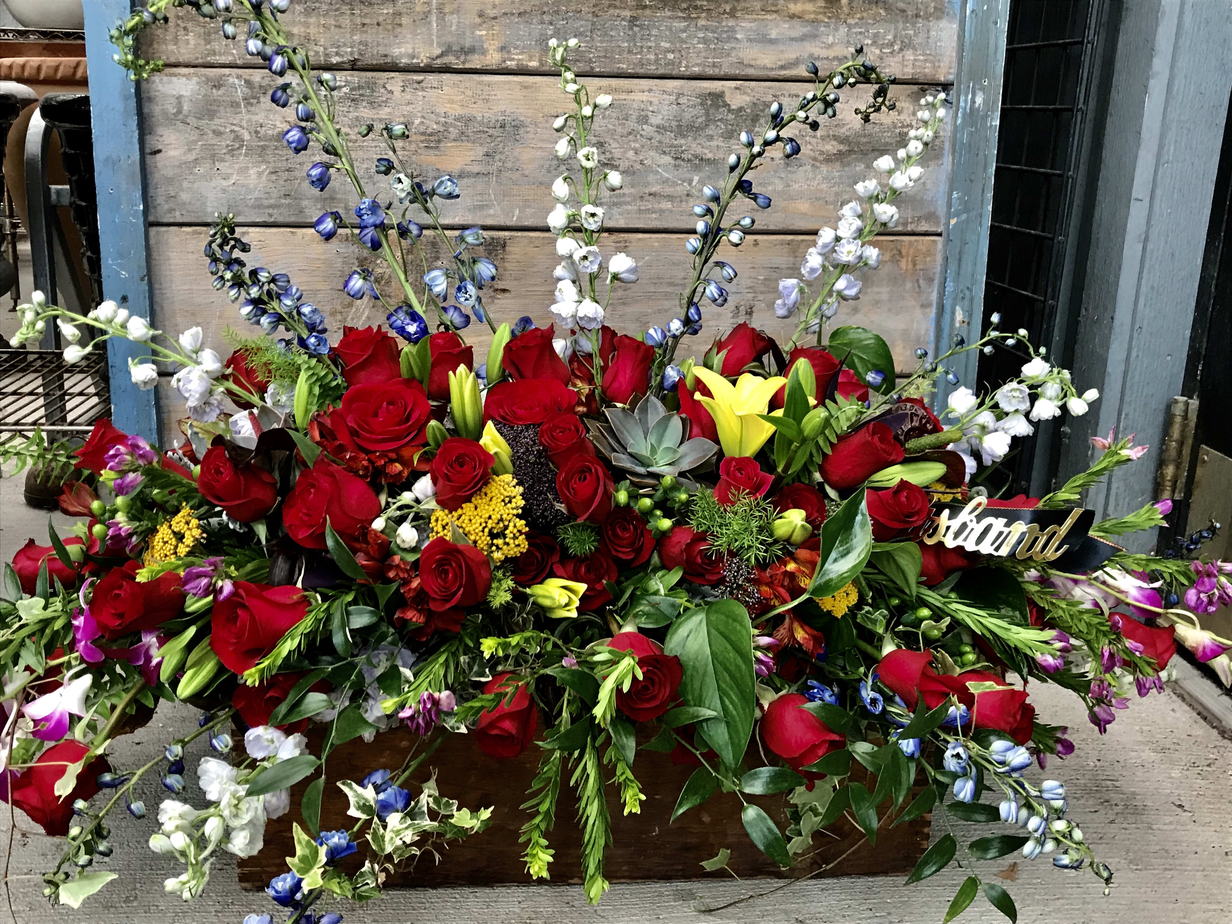 Red casket spray - Red designed casket spray with a hint of other blooms and colors.