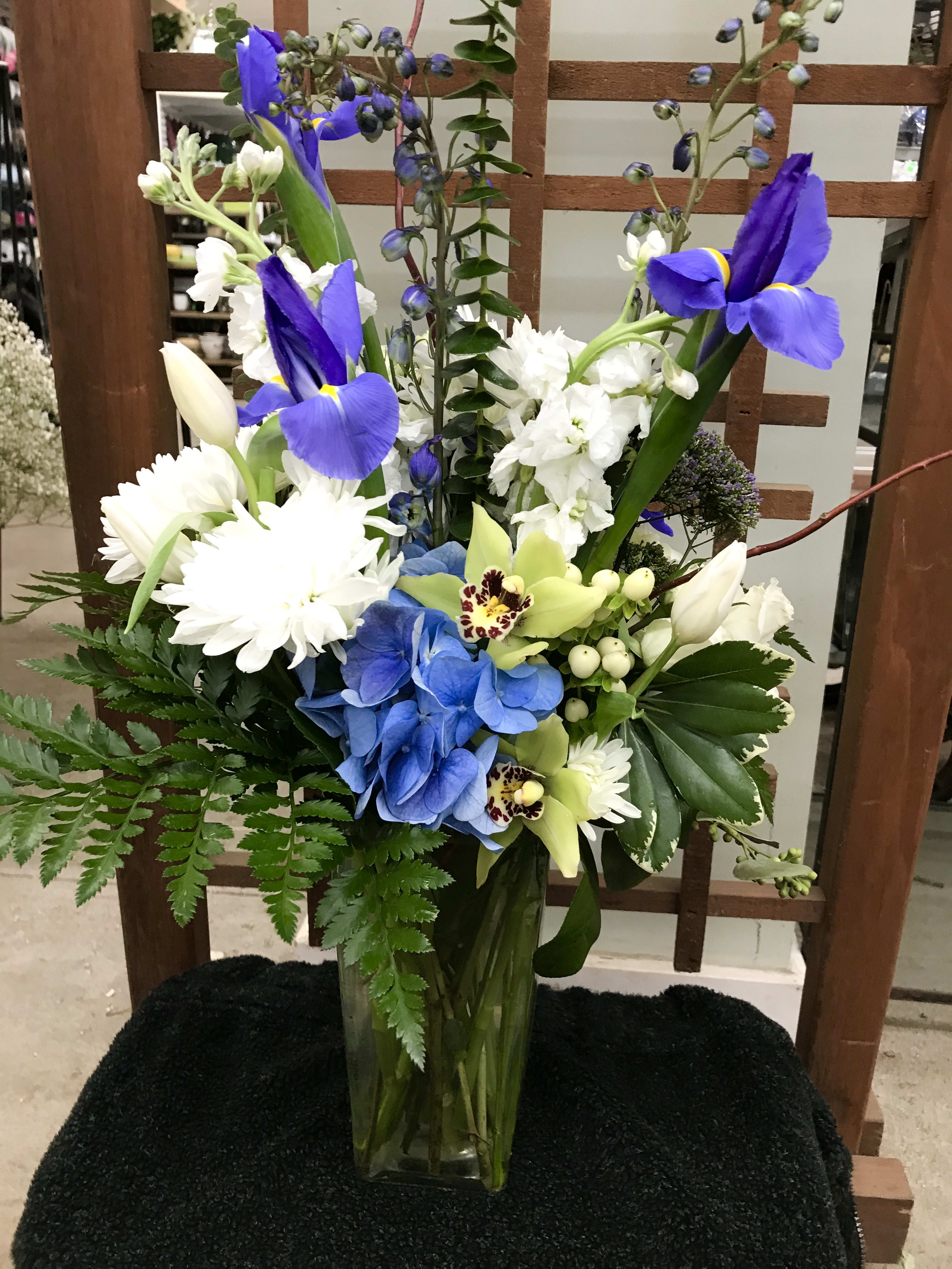 Blue and white Elegance. - A tall design of elegant seasonal blooms with interesting greens.