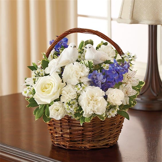Blue &amp; White Peace, Prayers &amp; Blessings - Offer peace and comforting prayers during times of loss with this elegant blue and white basket arrangement. A pair of graceful doves sits atop a gathering of fresh roses, delphinium, alstroemeria and carnations, beautifully hand-designed by our florists. Graceful blue and white arrangement of roses, delphinium, alstroemeria, carnations, mini carnations and monte casino, accented with variegated pittosporum and myrtle Hand-arranged in a willow handled basket with a pair of peaceful white dove picks; basket measures 8&quot;H Appropriate to send to the home of friends and family members or to the memorial service Large arrangement measures approximately 12&quot;H x 12&quot;L Medium arrangement measures approximately 11&quot;H x 11&quot;L Small arrangement measures approximately 10&quot;H X 10&quot;L Our florists hand-design each arrangement, so colors, varieties, and basket may vary due to local availability  Lilies may arrive in bud form and will open to full beauty over the next 2-3 days 
