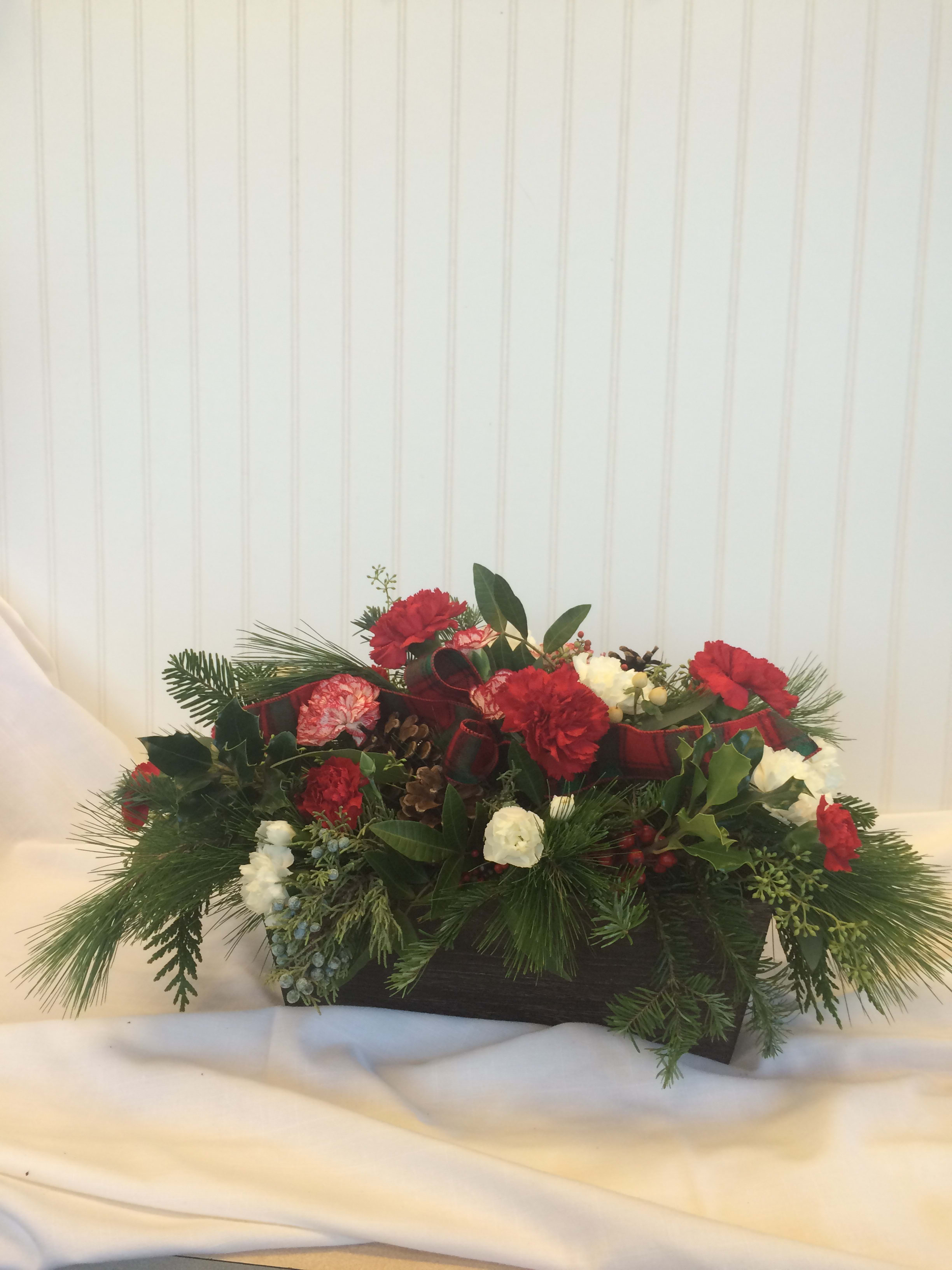 Holiday Centerpeice - A centerpiece of evergreens, red &amp; white carnations, pinecones &amp; ribbon designed in a wooden container for that nature lover. A more elegant container can be substituted with added silver or gold accents.