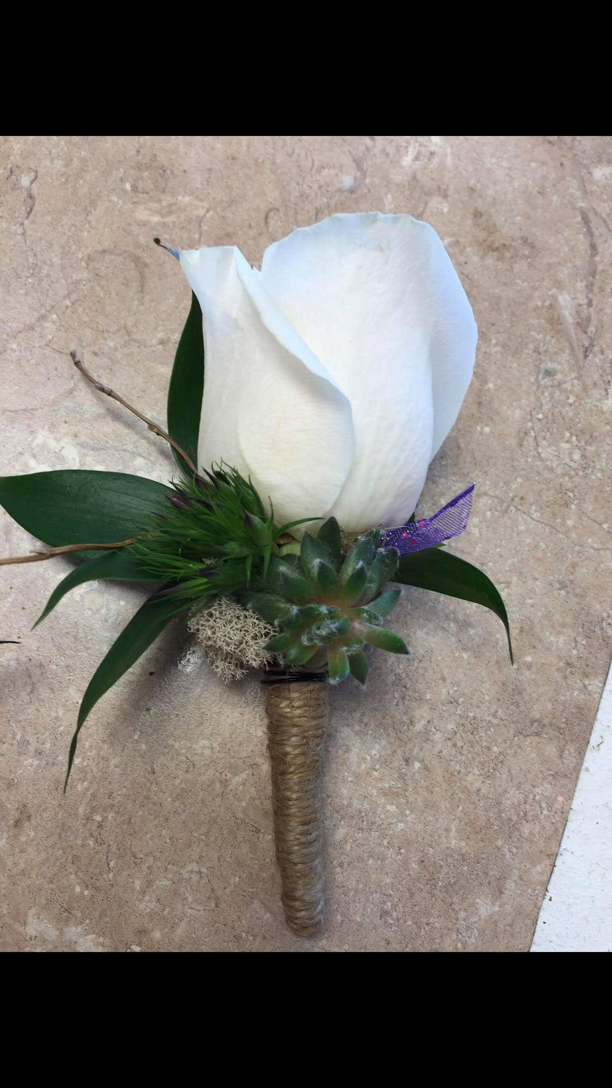 Boutonnierre - rose - Standard rose boutonniere. Your choice of color and ribbon accent. Upgrade to deluxe or premium for additional accents to match your outfit.   Available colors include red, white, pink, yellow, orange, purple, and champagne. 