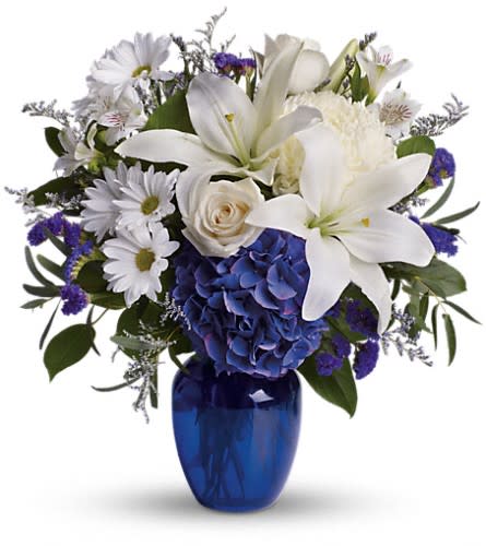 Beautiful in Blue - In this arrangement the serenity of the color blue along with the purity of intention symbolized by white will let the family know you are sending your calm strength to them during these difficult times. Beautiful blooms such as blue hydrangea cr?me roses white lilies and alstroemeria along with yellow and white chrysanthemums eucalyptus limonium and more are beautifully arranged in a dazzling cobalt blue vase.Approximately 16 1/2&quot; W x 18&quot; H Orientation: One-Sided As Shown : T209-3ADeluxe : T209-3BPremium : T209-3C